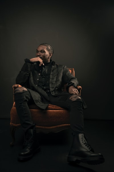 穿着黑色夹克的男人坐在棕色沙发椅上